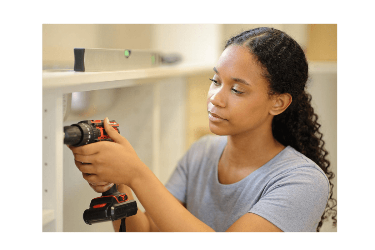 Woman assembling shelving with a power drill